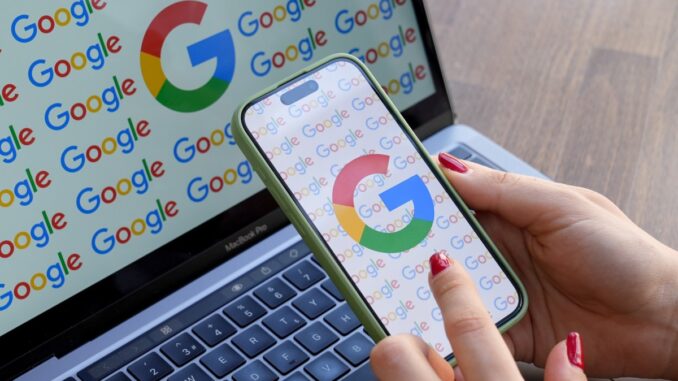 US DoJ wants Google to sell two of its ad A woman looks at a mobile phone displaying the logo of Google in front of a laptop screen displaying the logo of Google.