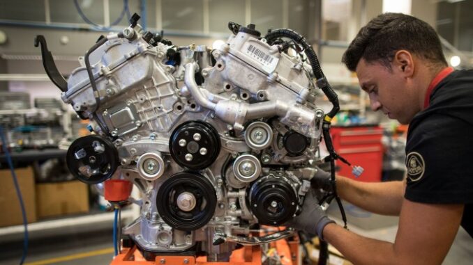 An employee works on a sports car engine at Lotus’s Hethel plant in Norfolk