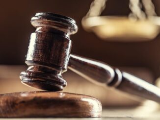 A judge's gavel with scales in the background.