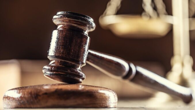 A judge's gavel with scales in the background.