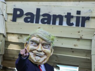 An activist dressed as U.S. President Donald Trump stands in front of a mock Trojan horse