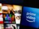 The logo of Amazon Prime Video against a blurred backdrop of tiles on a television screen.